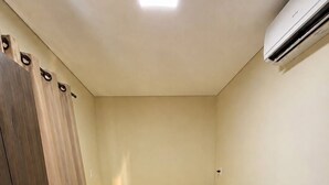 A bedroom with a bed, a wardrobe, and an air conditioning unit. - HOTEL IDEAL 2 (Inocencia)