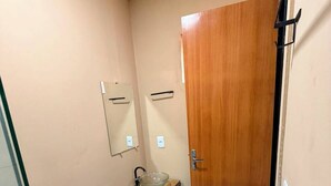 A small bathroom with a toilet, a sink, and a mirror. - HOTEL IDEAL 2 (Inocencia)