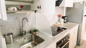 A kitchen with a stainless steel sink, a coffee maker, and a refrigerator. - Newly Renovated 2BR Apartment (Lince)