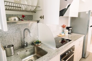 A kitchen with a stainless steel sink, a coffee maker, and a refrigerator. - Newly Renovated 2BR Apartment (Lince)
