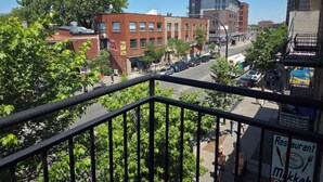A city street with buildings, trees, and a sign for a restaurant. - Modern 2BR • Steps to Jean-Talon Metro • Fast Wi-Fi • Long Stays Welcome (Montréal)