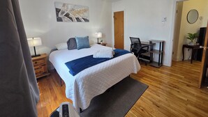 A hotel room with a bed, bedside lamps, a desk, and a chair. - Modern 2BR • Steps to Jean-Talon Metro • Fast Wi-Fi • Long Stays Welcome (Montréal)