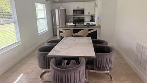 A modern kitchen with white cabinets, a stainless steel refrigerator, and a microwave. - Charming 3-bedroom house with AC in Sunny Cape Coral (Cape Coral)