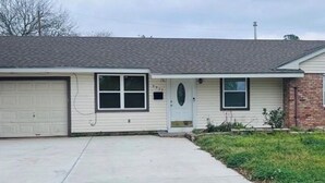 Einbungalow mit Garage, Eingangstür und kleiner Veranda.