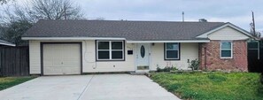 Einbungalow mit Garage, Eingangstür und kleiner Veranda.