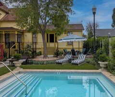 Una piscina al aire libre, sombrillas, sillones reclinables de piscina