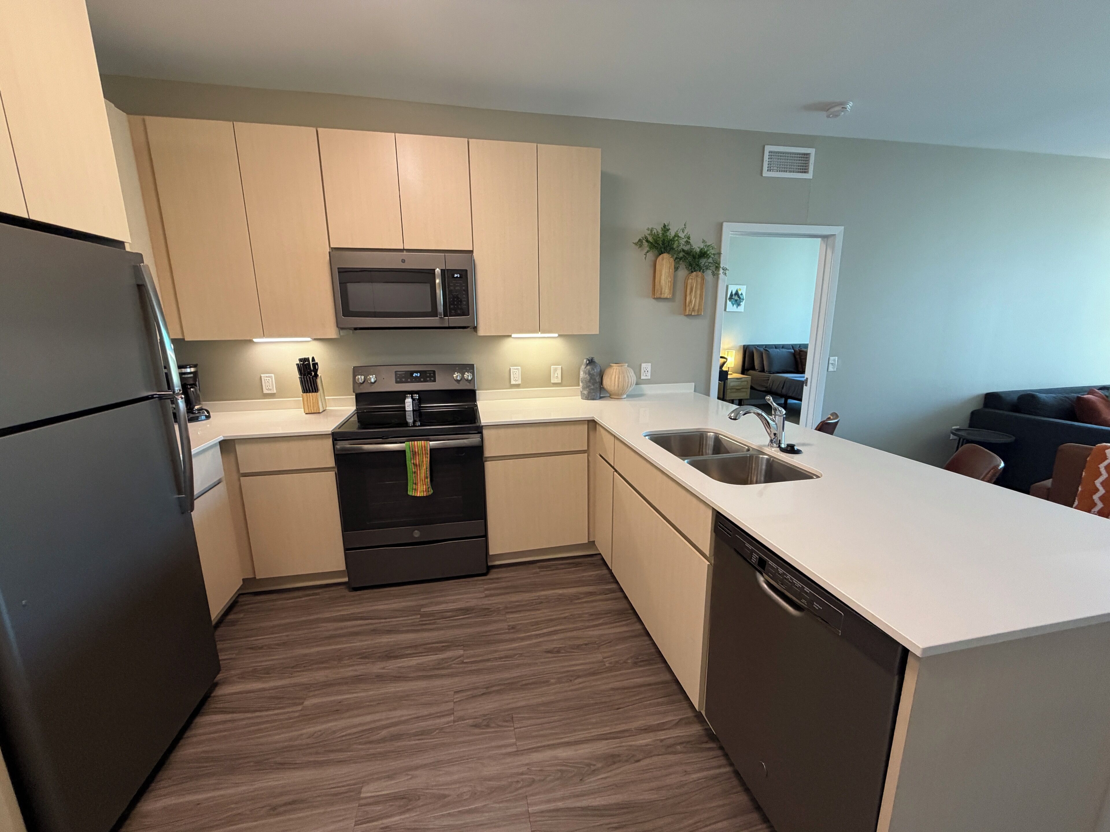 A modern kitchen with a built-in oven, microwave, and dishwasher.
