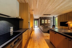 Eine moderne Küche mit Holzschränken, einer schwarzen Arbeitsplatte und einem eingebauten Herd.