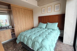 Ein Schlafzimmer mit einem Bett, einem Holzschrank und einer Kopfteil.