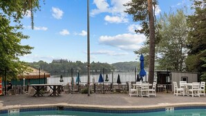 A poolside area with a pool, tables, chairs, and umbrellas. - Victorian Inn #226 | 2 Queen Beds (Elkhart Lake)
