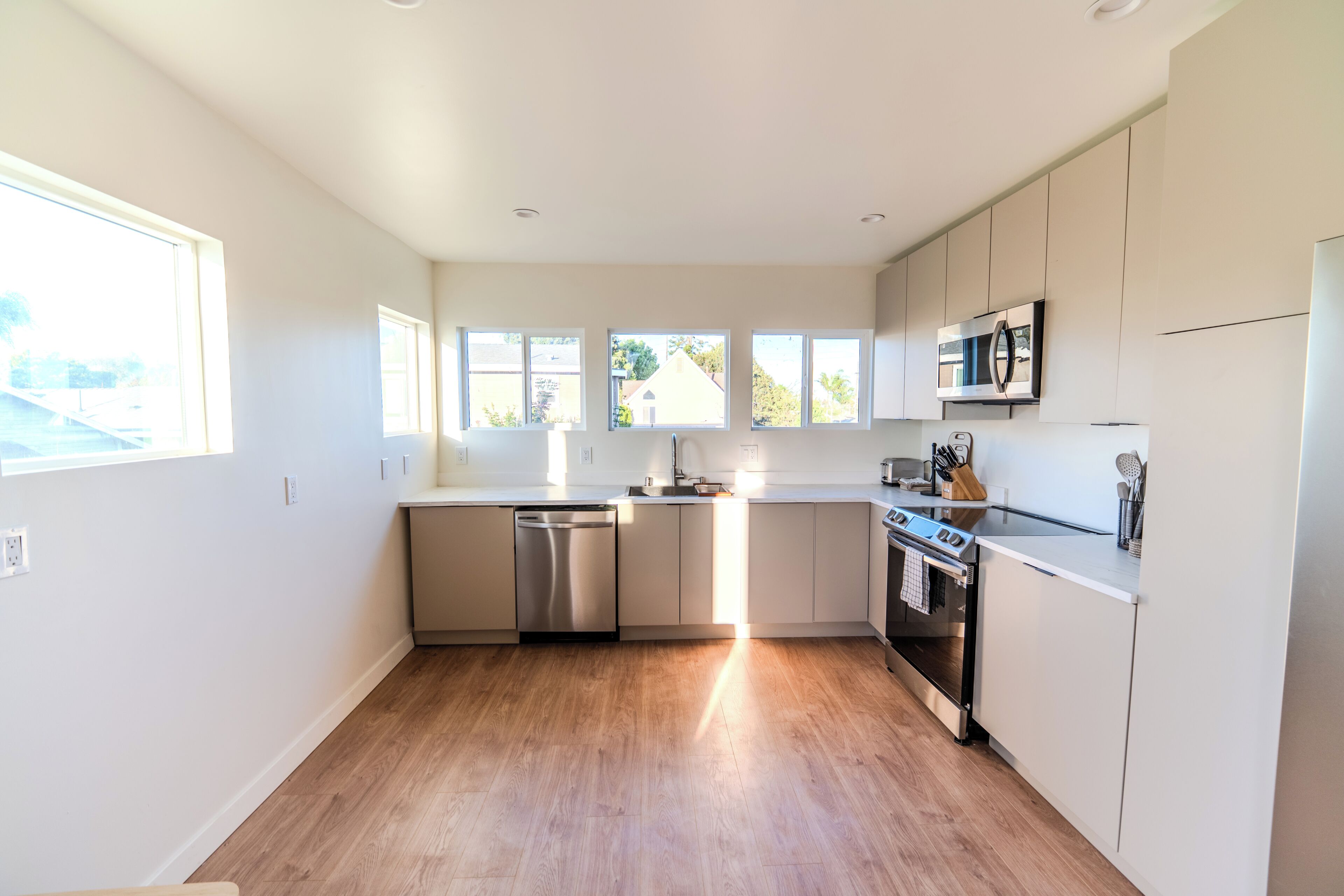 A modern kitchen with a dishwasher, oven, and microwave.