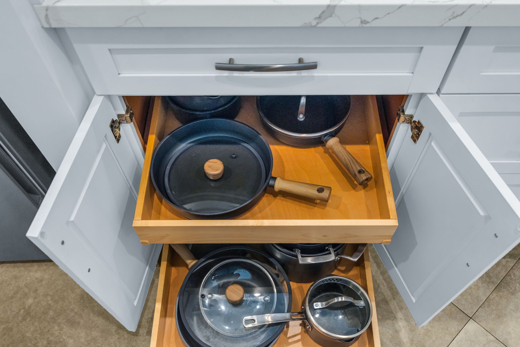 A kitchen drawer with pots and pans.