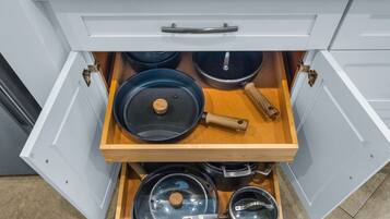 A kitchen drawer with pots and pans.