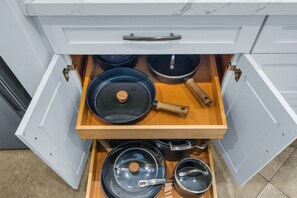 A kitchen drawer with pots and pans.