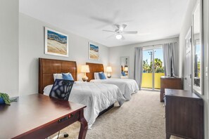 A hotel room with two beds, a desk, a ceiling fan, and a view of the outdoors. - Family-Friendly 3BR Townhouse with Outdoor Patio & Fire Pit 🌴 (Cape Canaveral)