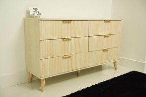 A light wooden chest of drawers with four drawers and a small sign on top indicating WiFi availability. - Skylux Ocean House: 3BR Private Pool, Game Room & Cinema-Size TV (Hollywood)