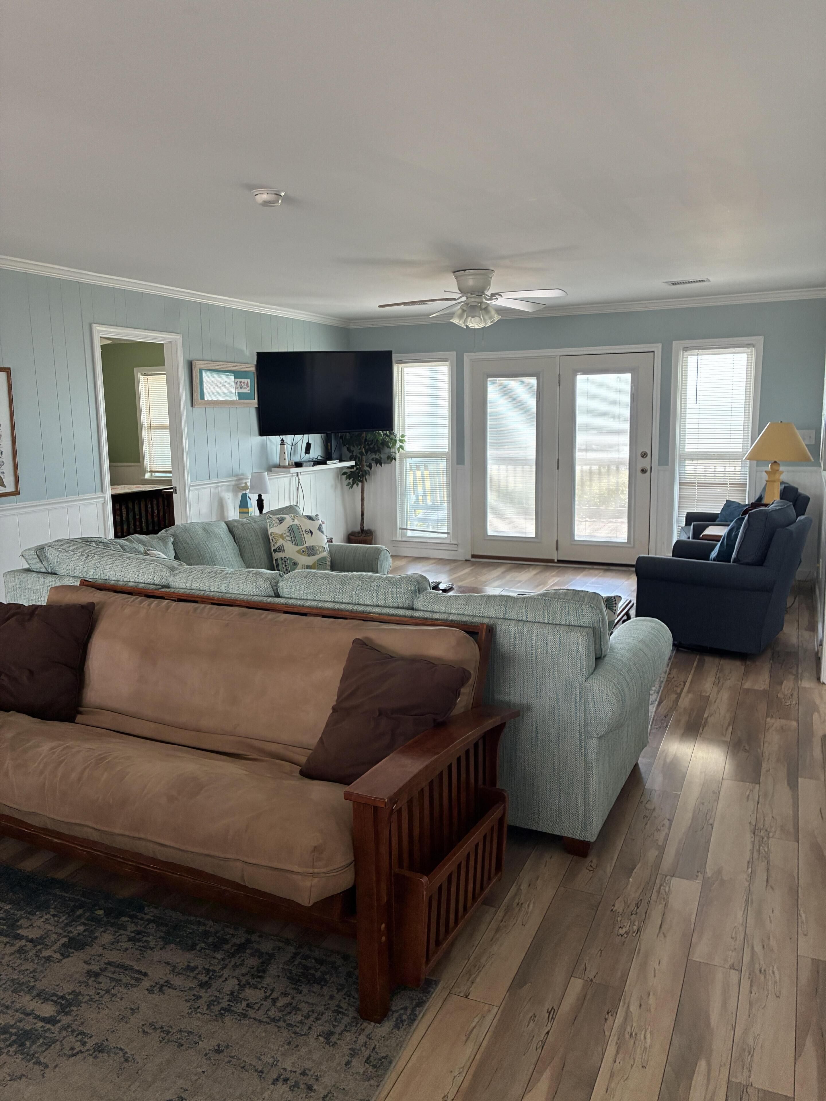 A living room with a brown sofa, a blue armchair, and a wooden coffee table.