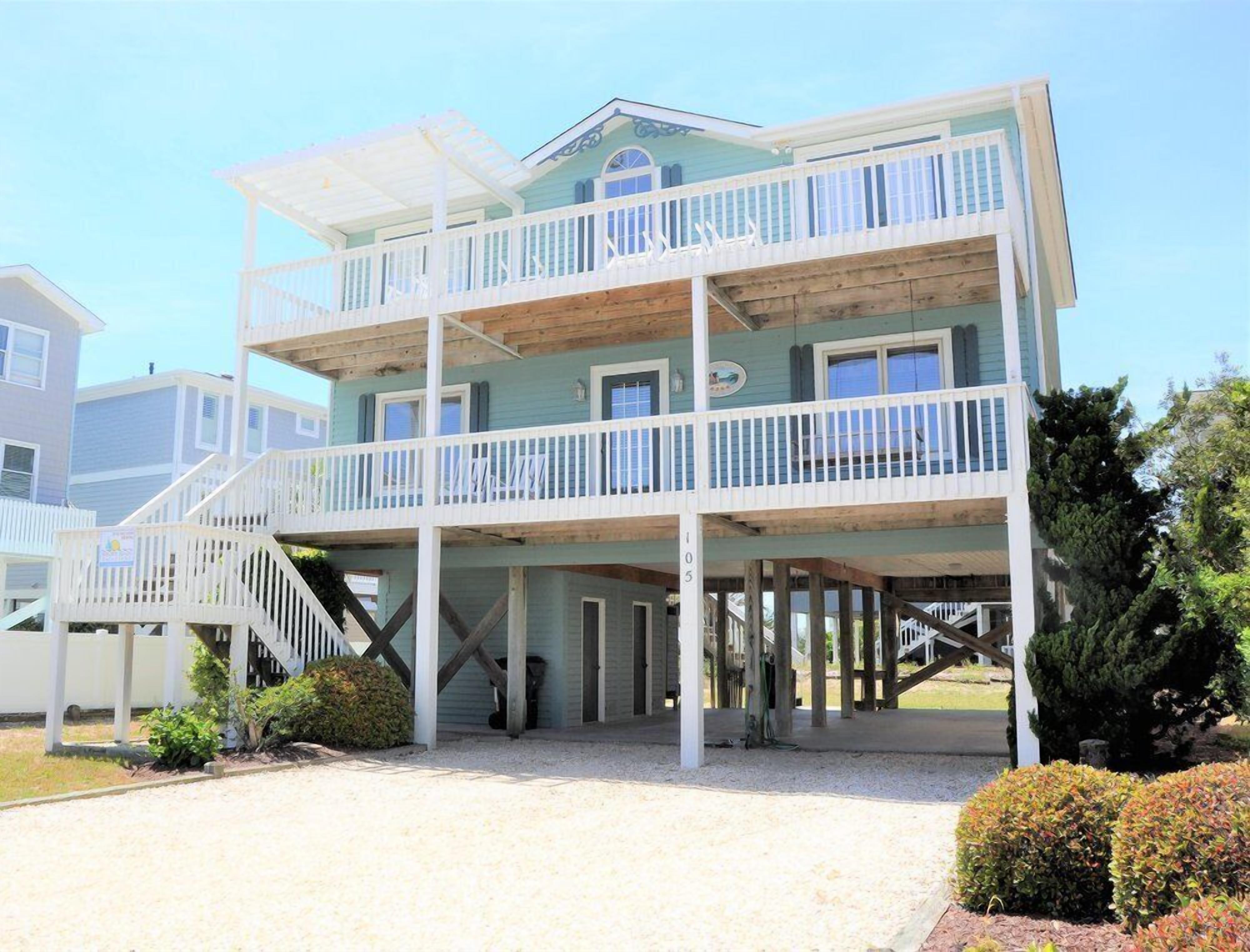 A multi-story building with a balcony, a staircase, and a covered area.