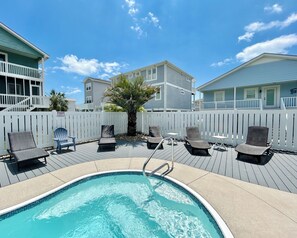 A swimming pool with lounge chairs and a wooden deck, surrounded by a white fence and houses. - 3BR Holden Beach retreat with private pool (Holden Beach)