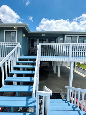 Un bâtiment à la façade bleue, avec des balustrades blanches et une enseigne portant le numéro « 106 ».