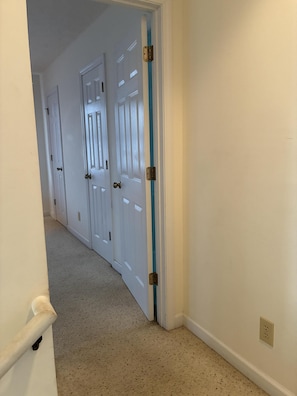 A hallway with white doors, a blue stripe, and a carpeted floor. - 4BR, 4.5BA  Holden Beach home (Holden Beach)