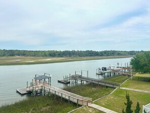 A riverside dock with wooden walkways and a grassy area. - 4BR retreat with dock overlooking the ICW (Holden Beach)