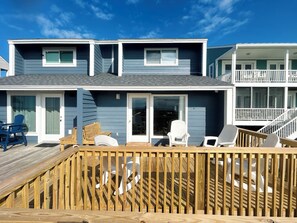 A two-story building with a deck, outdoor seating, and a covered area. - Oceanfront 3BR, 2BA Holden Beach getaway (Holden Beach)