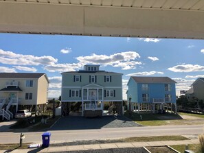 A residential area with a two-story house featuring a front porch and a garage. - 4BR, 2BA Holden Beach retreat located on the 2nd row (Holden Beach)
