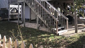 A two-story building with a wooden staircase leading to a balcony. - 4BR, 2BA Holden Beach retreat located on the 2nd row (Holden Beach)