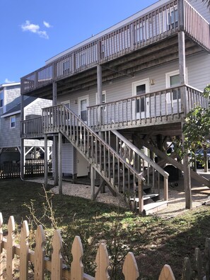 A two-story building with a wooden staircase leading to a balcony. - 4BR, 2BA Holden Beach retreat located on the 2nd row (Holden Beach)