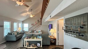 A spacious living area with a dining table, sofas, and a staircase leading to an upper level. - 4BR, 2BA Holden Beach retreat located on the 2nd row (Holden Beach)