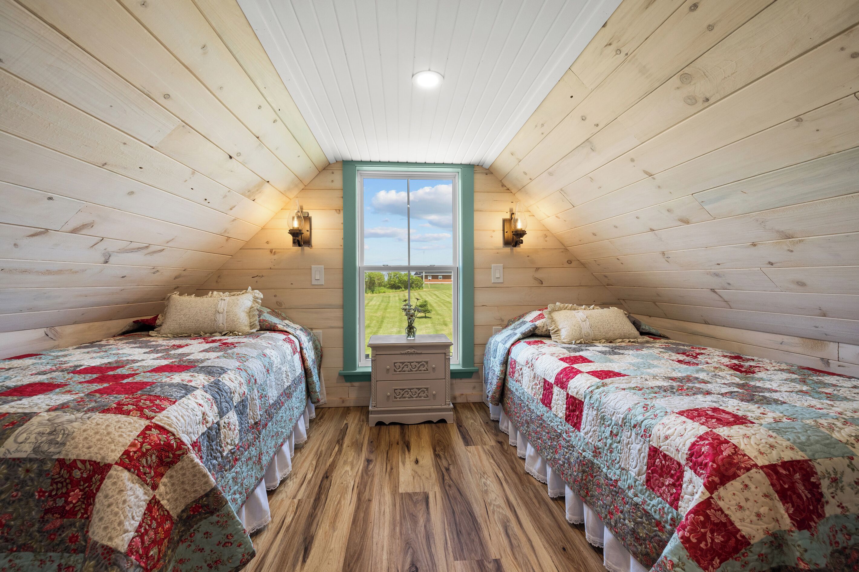 A room with two beds, a window, and a view of the outdoors.