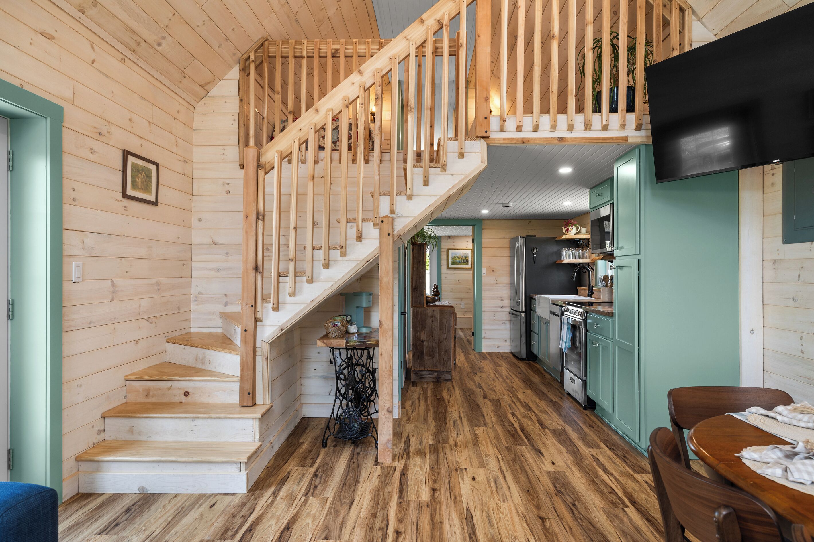 Un intérieur en bois comprenant un escalier, un coin cuisine et une table à manger.