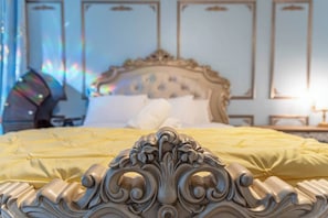 A bed with an ornate headboard, a yellow bedspread, and a nightstand with a lamp. - Whimsical Couple's Escape: Minutes to Disney (Kissimmee)