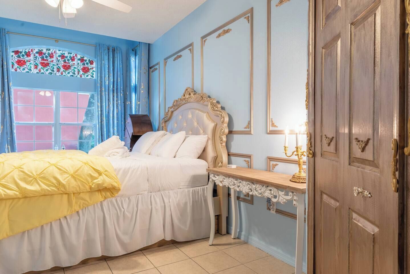 Ein Schlafzimmer mit Bett, Schreibtisch, Lampe und Tür.
