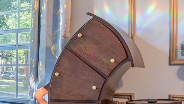 A room with a curved wooden furniture piece, a small table, and a window with curtains. - Whimsical Couple's Escape: Minutes to Disney (Kissimmee)