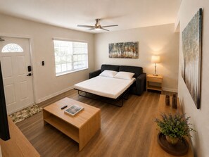 A bedroom with a bed, a desk, a lamp, a painting, and a door. - Coconut Grove Area - Modern Home - Sleeps 6 (Miami)