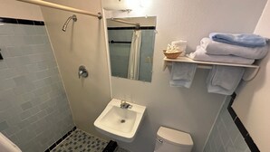 Kylpyhuone, jossa on suihku, pesuallas, wc ja pyyheteline pyyhkeineen.