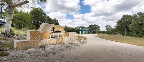 A sign for Hummel Hill with a road leading to a building.