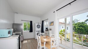 Ett kompakt kök med matplats, tvättmaskin och utsikt över omgivningarna.