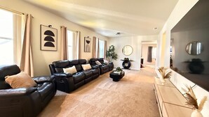 Una sala de estar con un sofá modular, una mesa de centro y un televisor sobre un mueble.