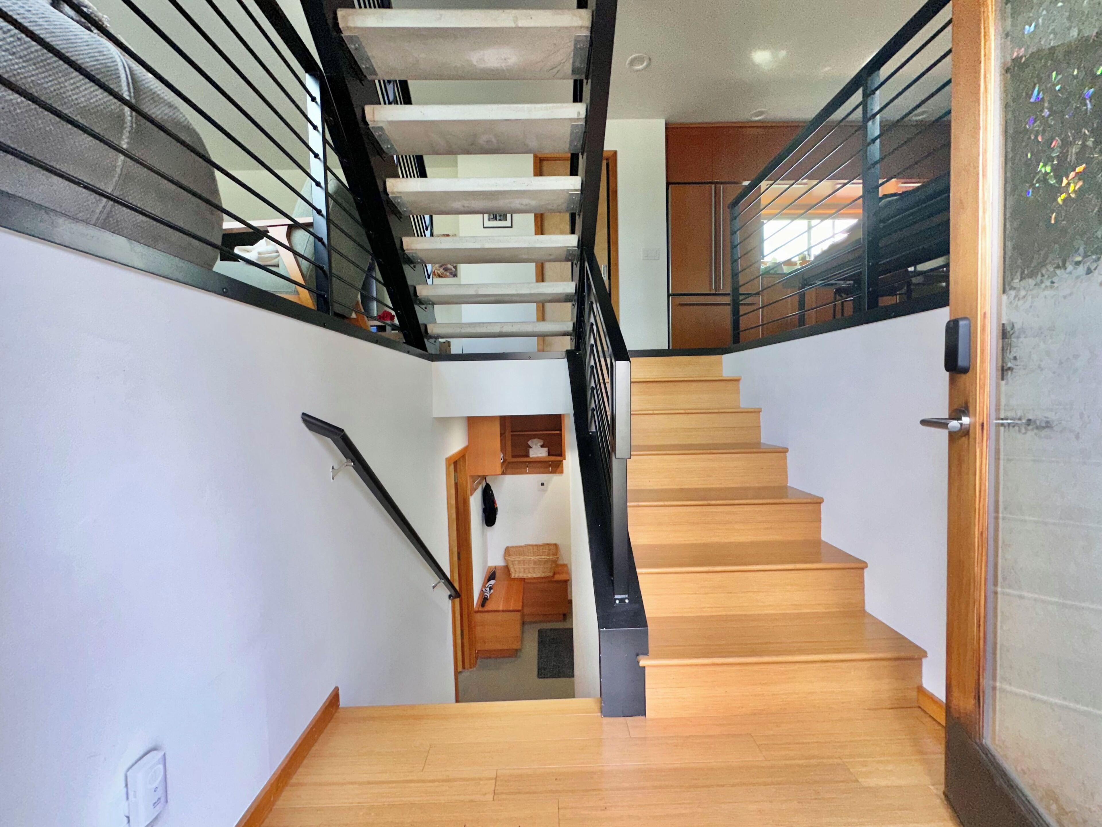 A staircase with wooden steps and metal railings, leading to an upper level.