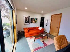 A living room with a sofa, a coffee table, a door, and a window. - Magnolia Salmon Bay Calling · Rooftop Views (Seattle)