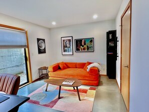 Ein Wohnzimmer mit einer Couch, einem Couchtisch und Kunstwerken an den Wänden.