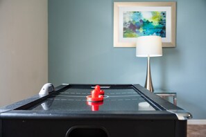 A pool table with a red puck in the center, a white puck on the left, and a framed abstract painting on the wall. - Sunset Swims & Disney Dreams-Modern Family Oasis (Davenport)