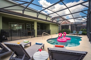 An indoor swimming pool with lounge chairs and two flamingos. - PROMO read below-Near Disney -Private POOL (Davenport)