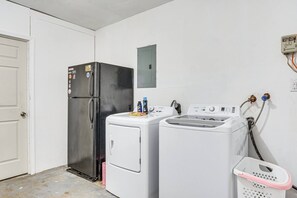 A laundry room with a refrigerator, washing machine, dryer, and a utility meter. - Pet Friendly, Private Pool - Between top 3 US Beaches (Gulf Breeze)