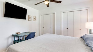 A bedroom with a bed, a desk, a ceiling fan, and two doors. - Pet-Friendly Family Getaway Near Two Beaches (Gulf Breeze)