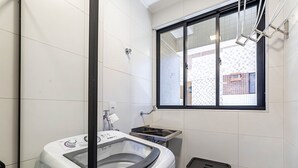 A compact laundry room with a washing machine, a small sink, and a trash bin. - Ap W/ocean View in a Cond. With Pool Sli0601 (Maceió)