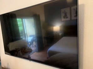 Ein Hotelzimmer mit Bett, Stuhl, Schreibtisch und Fenster.